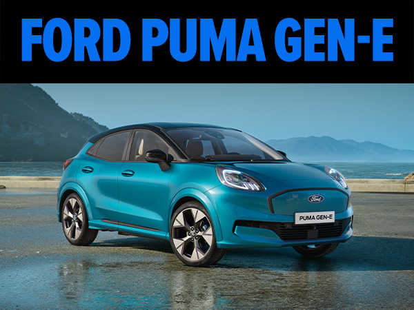 Ford Puma Gen-E in leuchtendem Gelb fährt dynamisch auf einer urbanen Straße bei Nacht.