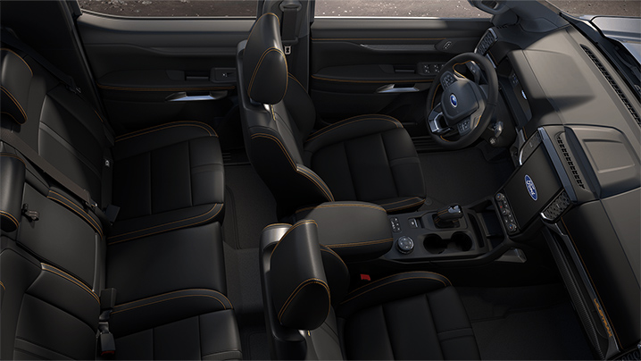 Innenansicht eines Autos mit schwarzem Lederinterieur und modernen Armaturen, von oben fotografiert.