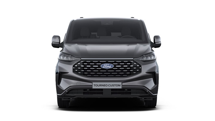 Frontansicht eines silbernen Ford Tourneo Custom mit markanter Kühlergrill und modernen Scheinwerfern.