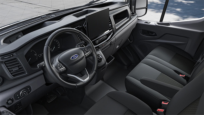 Innenansicht eines Ford-Fahrzeugs mit Lenkrad, Armaturenbrett und Vordersitzen in modernem Design.